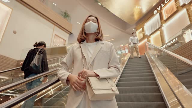 亚洲妇女在购物中心戴着医用口罩。