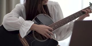 专心学习弹吉他的女人