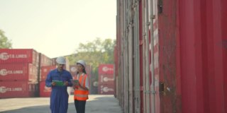 两名工程师男女工人在码头检查检查讨论，在一个大型工业港口前，工程师或工头或工人一起检查和讨论船厂的工作概念