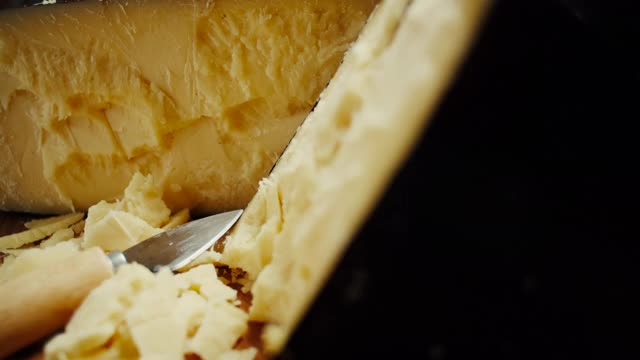 中等硬度的帕尔玛干酪头放在木板上，旋转拍摄