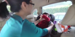 亚裔妈妈带着她的儿子坐在汽车座椅上