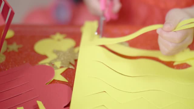 年轻的女孩在家里制作传统的中国新年工艺品来庆祝