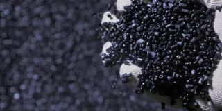 塑料黑灰色颗粒状的碎屑。生产塑料水管的工厂。用水和空气的压力在机床上制造塑料管的工艺。