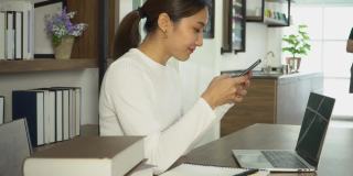 年轻的亚洲女性在网上用智能手机聊天。