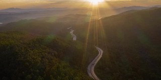 在日出中蜿蜒的道路山谷的超陷