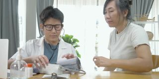 亚洲医生男孩用血压测量病人在家，生活方式的家庭生活方式概念。