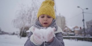 快乐的女孩从她的手掌吹雪