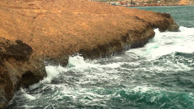 海浪拍打着岩石。地中海风暴。大海是绿松石色的。缓慢的运动。