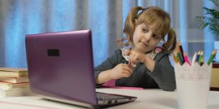 女童在笔记本上写作业，在家使用笔记本电脑，进行在线教育