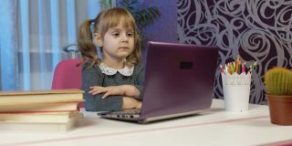 女孩做在线作业与老师，使用数字笔记本电脑在家里，远程教育