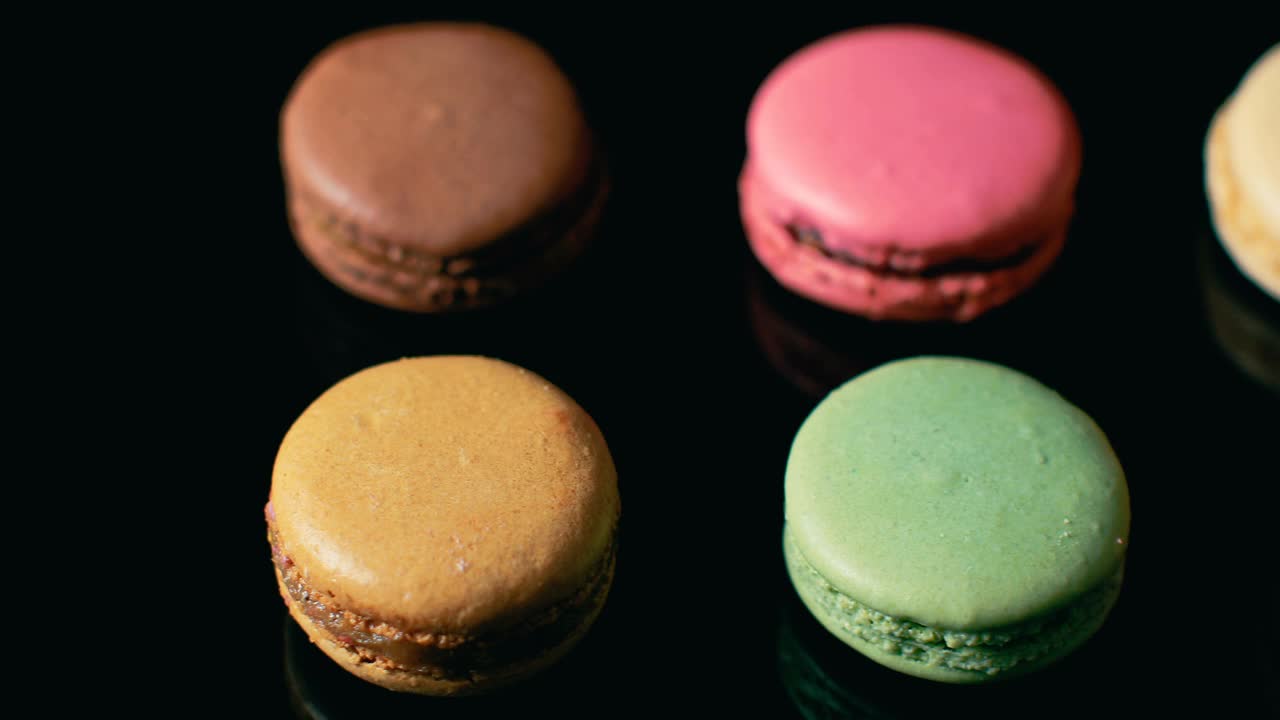彩色的法式马卡龙，黑色的背景。美味的传统法式甜点。法国的奢华甜点。