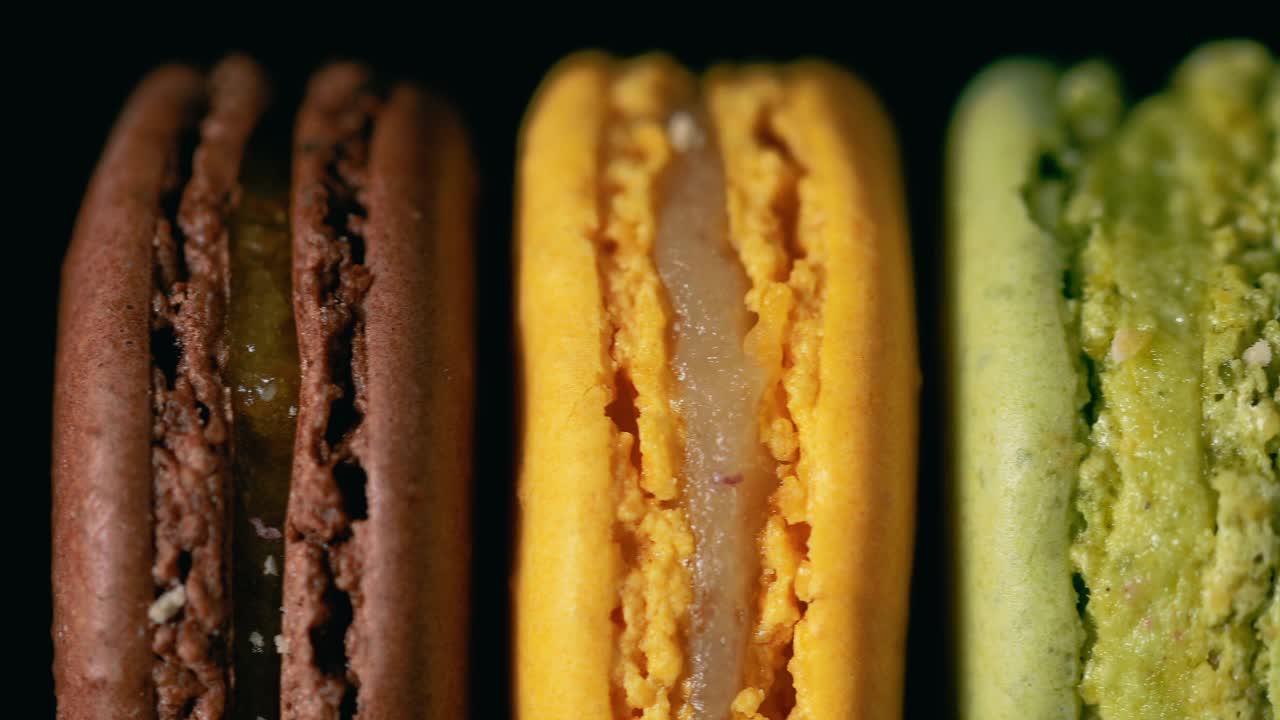 彩色的法式马卡龙，黑色的背景。美味的传统法式甜点。法国的奢华甜点。