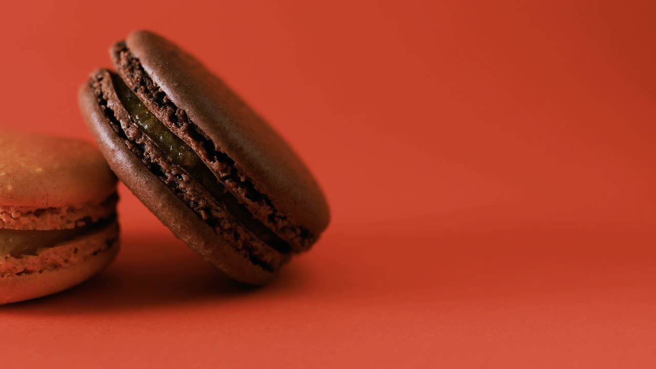 棕色和橙色的法式杏仁饼干配上黑色的背景。美味的传统法国甜点近距离