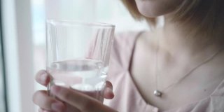 亚洲女人在家里喝水的慢镜头
