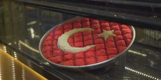 在加齐安泰普欣赏美味的土耳其果仁蜜饼。土耳其国旗的形状