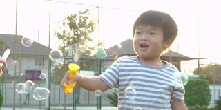亚洲小男孩在公园里玩肥皂泡