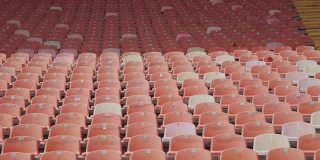 红色的空塑料座位在体育场排成一排。
