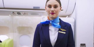 飞行期间，机组人员在飞机上为顾客服务。新的正常程序，空乘人员和所有乘客戴上口罩，预防新冠肺炎疫情。