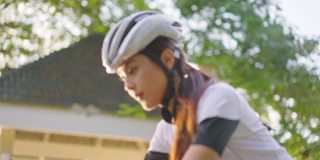 亚洲年轻美丽的女人骑自行车为健康在晚上在公共公园。运动员健康和坚定的女孩在运动服装锻炼通过自行车锻炼运动为她的健康健康。