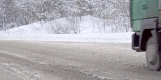 高速公路上，松散的雪花从卡车车轮下飞舞
