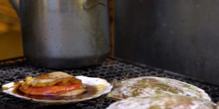 亚洲鱼市街头，慢镜头小贩在钢烤架上烹饪扇贝