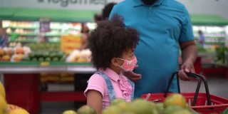 爸爸和女儿在超市用智能手机买水果——还戴着口罩