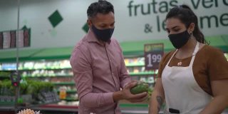 超市工作人员帮顾客买牛油果戴口罩