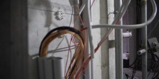 电线从墙上伸出来，修理电线
