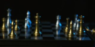 商人在棋局中移动白王击败对手黑王的特写，计划和战略思路