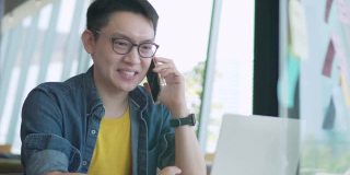 特写英俊的亚洲年轻人在使用笔记本电脑聊天，使用网络摄像头，户外技术工作互联网。他正在家里开视频会议