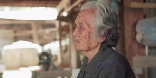 中等近距离拍摄的年长妇女与短灰头发坐在和谈论在当地的家，亚洲资深妇女的肖像，老年妇女的概念