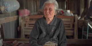 中等拍摄的年长妇女与短灰头发坐在和交谈在当地的家，亚洲资深妇女的肖像，老年妇女的概念
