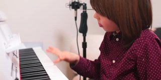 少年在音乐课上富有表现力地按钢琴键天才儿童