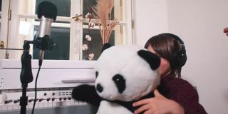 灵感儿童耳机是跳舞的熊猫坐在工作室的麦克风前