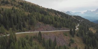 航拍的意大利阿尔卑斯山的山路上，一对夫妇骑着冒险摩托车