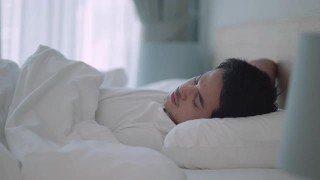 亚洲男人睡甜蜜的梦在一个舒适的午睡在床上在房子里的卧室视频素材模板下载