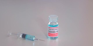 医生病毒学护士带着疫苗瓶、注射器、注射剂量、疫苗安瓿、Covid-19冠状病毒脱落物在医学实验室