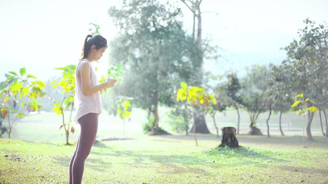 亚洲女性在公园使用智能手机
