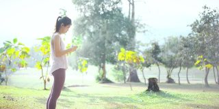 亚洲女性在公园使用智能手机
