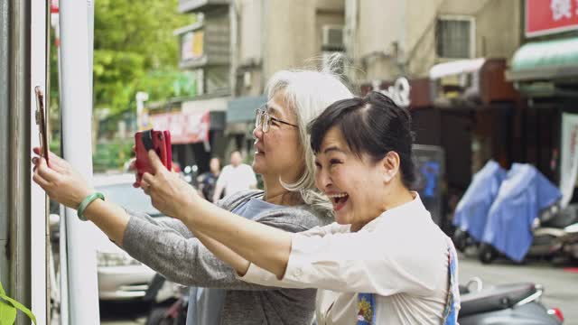 高级女性朋友用智能手机逛街