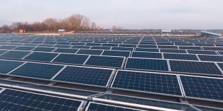 可持续能源。现代光伏电池在平屋顶上。创新的太阳能电池板从太阳中产生生态能源。鸟瞰图。运动镜头。