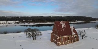 冬季航拍的独特的、真实的哥特式的施洗者圣约翰查布斯基斯老教堂位于Nemunas河岸边的山谷