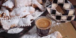 嘉年华食品和嘉年华面具。Sfrappole或chiachiere或天使翅膀和芳香的咖啡在木质背景。传统的甜酥酥皮经油炸后撒上糖粉。