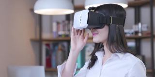 快乐的亚洲女性与虚拟现实齿轮耳机在家