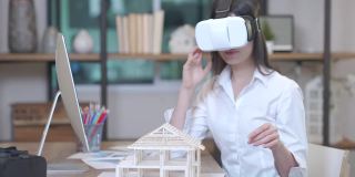 一位女建筑师使用虚拟现实头盔(VR Gear)来模拟室内设计和房屋建造。