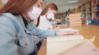 女大学生在大学图书馆看书视频素材模板下载