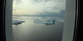 北冰洋游艇舷窗上的冰和冰山。
