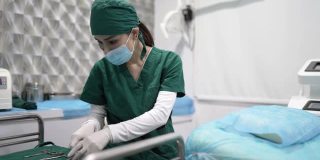 亚洲华裔女医生正在准备手术工具。
