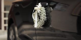 用婚礼花和缎带装饰婚车。婚礼装饰。婚礼装饰的设计。鲜花上的婚礼现代车