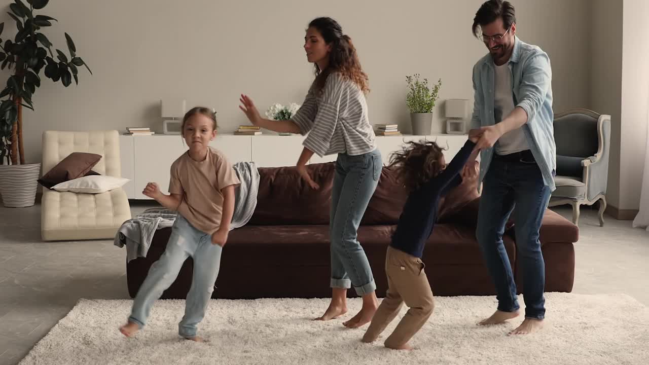 一对夫妇带着孩子在客厅跳舞